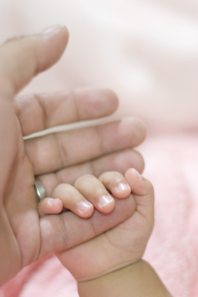 Babyhand hällt Finger von Mutter
